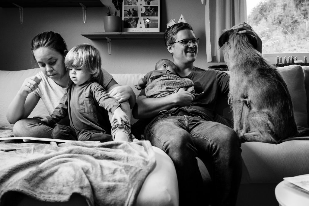 Natürliches Familienportrait inklusive des Hundes auf der eigenen Couch in Kreuztal